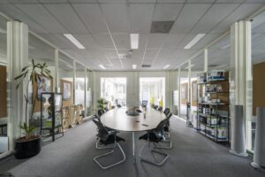Vergaderruimte aan de Van der Madeweg met ovale tafel, kantoorstoelen, planten en presentatieproducten van BCC.